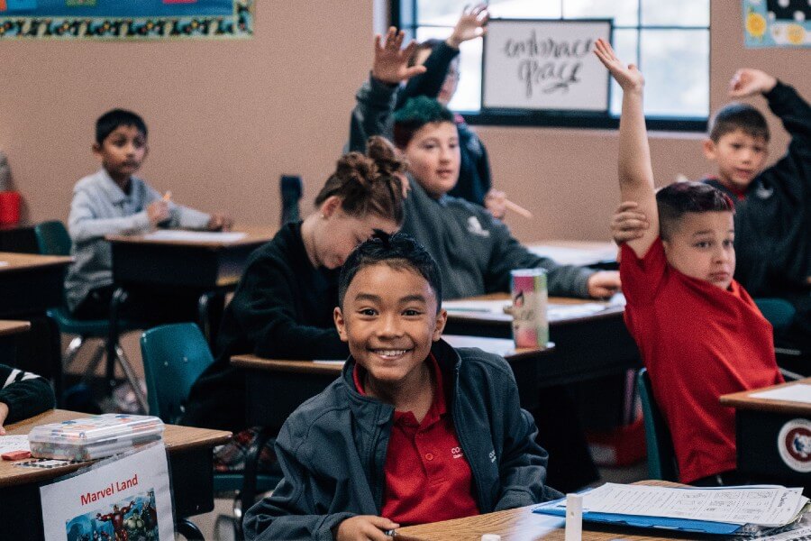 kids learning and raising their hands